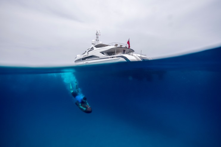 A man dives beneath the Amore Mio yacht