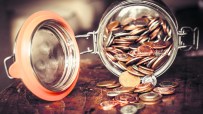 Jar filled with coins symbolizing cautious saving habits of older Brits avoiding stock market investments for retirement s...