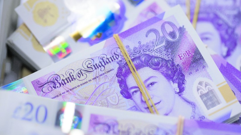 Bundles of new polymer British 20-pound banknotes sit in a basket. De La Rue supplies the Bank of England. Photographer: Jason Alden/Bloomberg via Getty Images