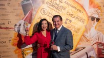 Libby Brodie and Matthew Jukes raising a toast at a celebratory event, smiling and holding a glass, conveying joy and success