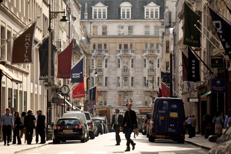 Mayfair street view showcasing luxury shops, bustling activity, and elegant architecture in a prominent business district