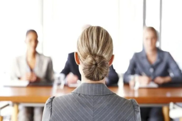 Professional job interview setting with diverse candidates seated at a table, highlighting workplace diversity and inclusion.