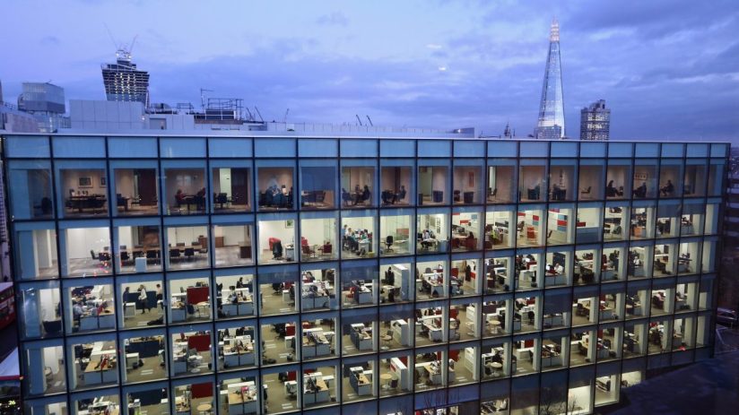 London office workers collaborating on AI and tech projects, surrounded by computers and digital interfaces in a modern wo...