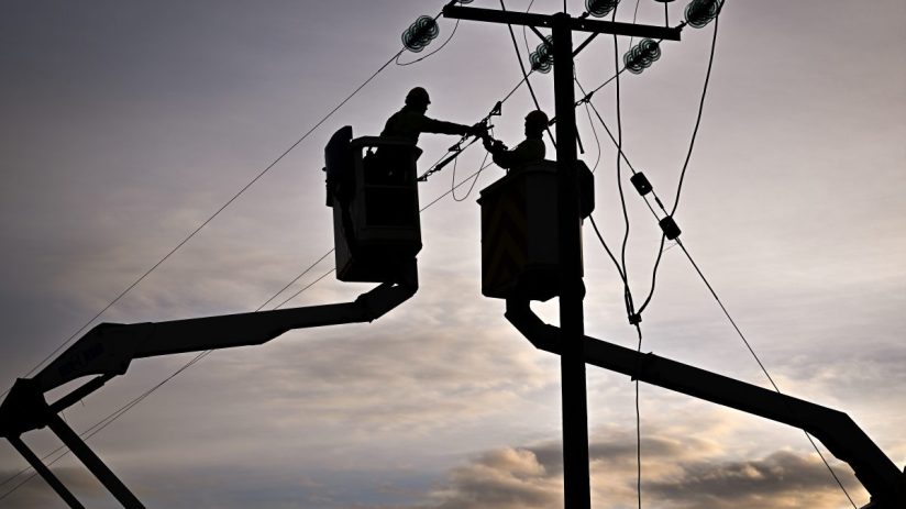 UK energy power lines spanning a rural landscape, highlighting infrastructure and sustainability efforts in the energy sec...