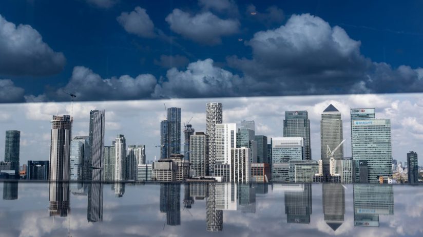 Canary Wharf skyline with prominent bank buildings under clear blue sky, highlighting Londons financial district.
