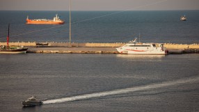 Bustling shipping activity in the Strait of Hormuz with tankers and cargo ships navigating Iranian waters.