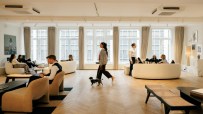 Halkin conference room with modern decor, large meeting table, and cityscape view through floor-to-ceiling windows