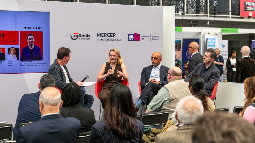 Dougal Shaw, Steph Hind, Gurinder Dhillon, and John Stapleton speaking on stage at SCALE 2 business event