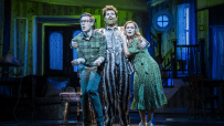 Beetlejuice musical cast performing on stage at the London production, showcasing vibrant costumes and set design