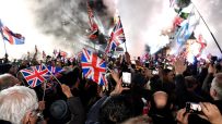 Brexit Leave party gathering with attendees holding Union Jack flags, highlighting the political atmosphere post-Brexit.