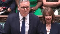 Keir Starmer speaking passionately at Prime Ministers Questions in the UK Parliament chamber, addressing government policies.