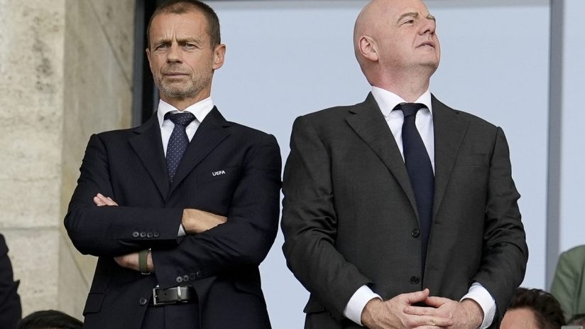 Aleksander Čeferin, UEFA President, and Gianni Infantino, FIFA President, observing from a stadium box.
