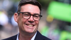Andy Burnham, Mayor of Greater Manchester, smiling and wearing glasses outdoors.