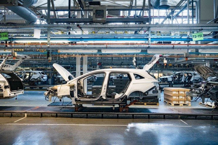 Car bodies on an assembly line in a UK car plant, showcasing EV manufacturing process