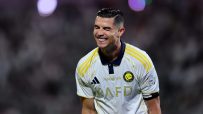 Cristiano Ronaldo smiling in his white and yellow Al Nassr football jersey during a match