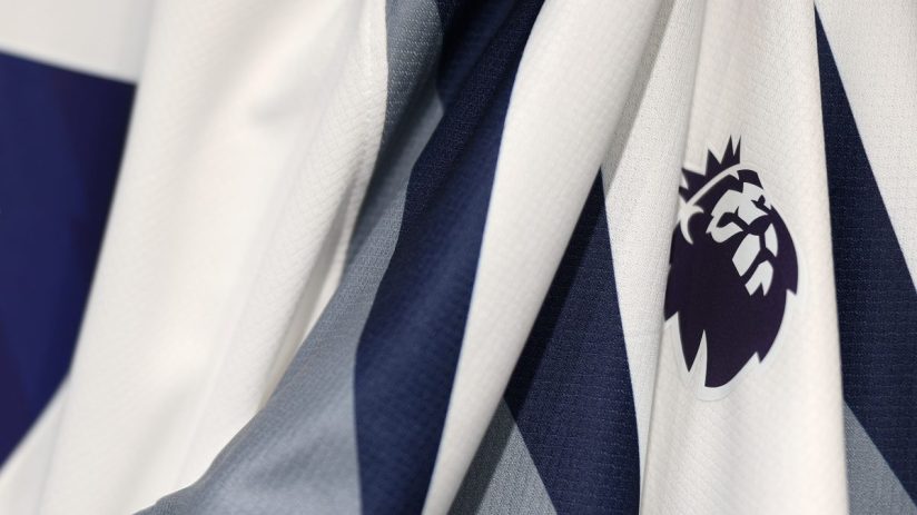 Close-up of a white and navy blue sports jersey with the Premier League logo emblem on the fabric