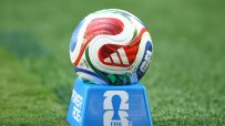FIFA World Cup 2026 soccer ball on a blue stand with the FIFA logo, on a green grass field.