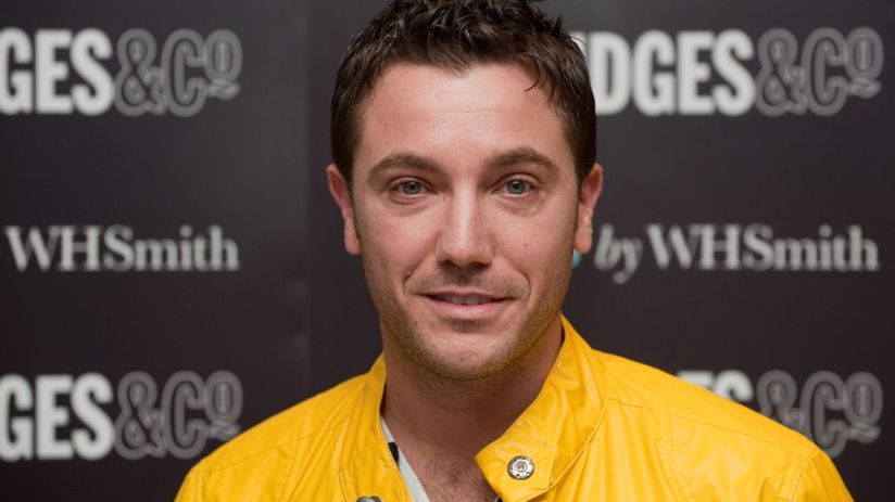 Gino DAcampo, smiling in a bright yellow jacket, against a dark background with GES & CO and WHSmith logos
