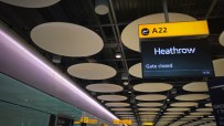 Heathrow airport terminal with Gate closed flight information display and modern ceiling design, highlighting infrastructure.