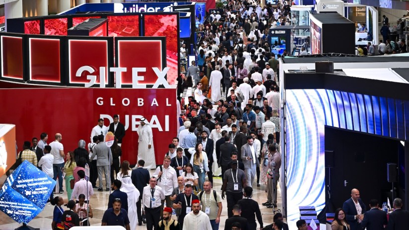Crowd of diverse attendees at GITEX GLOBAL DUBAI tech exhibition, with GITEX signage visible.
