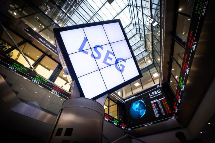 LSEG logo on a large screen inside a modern building with stock tickers and glass ceilings.