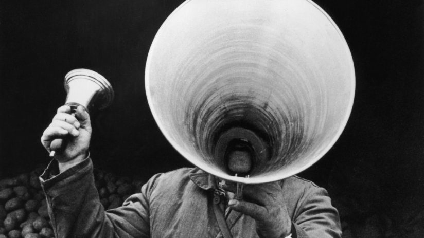Person holding a megaphone, emphasizing a key announcement in a general news article on a business website.