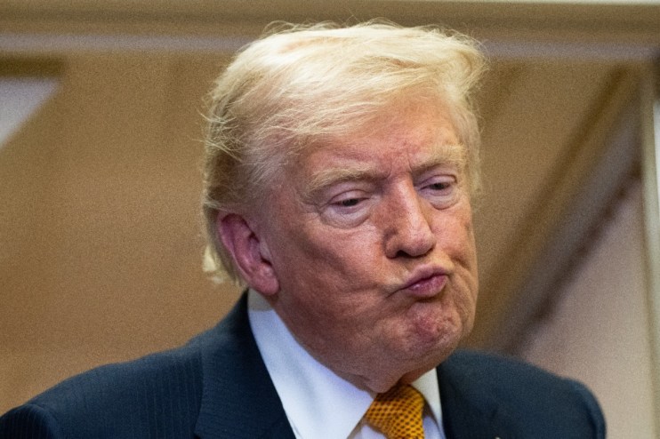 Donald Trump delivering a speech at a podium during a formal event, emphasizing key points to an attentive audience.