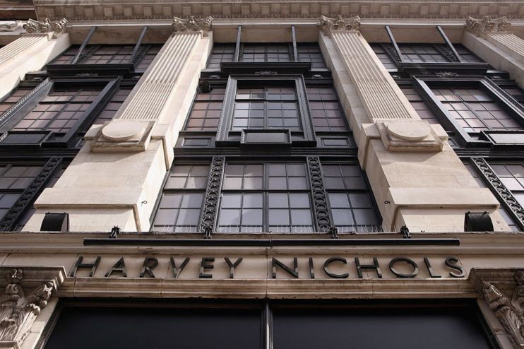 Exterior view of the Harvey Nichols luxury department store building facade with prominent black lettering and ornate arch...