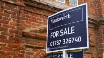 Winkworth estate agent For Sale sign in front of a brick building, indicating property prices and availability.